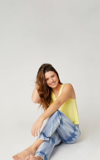 Woman model wearing yellow tank top and EverStretch jeans.