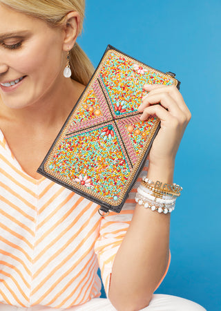 Woman model holding a multicolored summer wallet handbag.