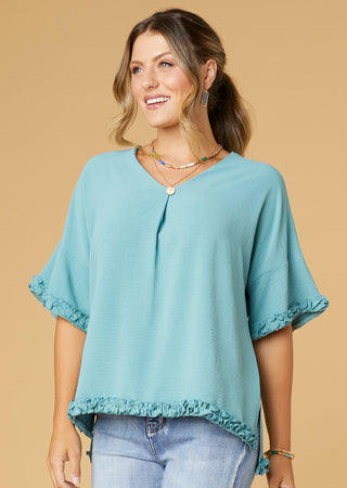 Woman model wearing blue summer top.