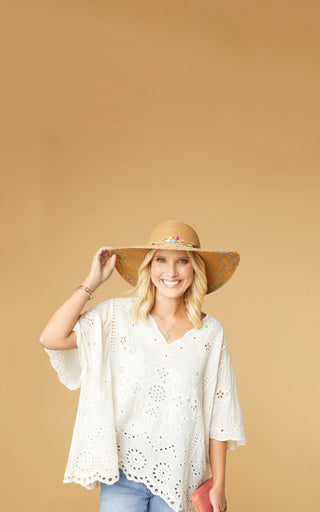 Model wearing white top and ranch hat.