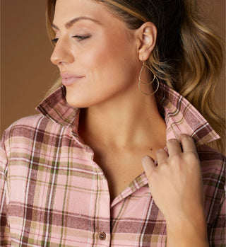 Model wearing a pink plaid flannel and dangle earrings.