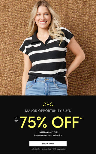 Woman in black and white striped shirt and blue jeans standing next to a promotional banner for a up to 75% off sale.