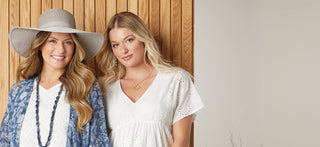 Two models. One wearing a light blue ruana and ranch hat. The other wearing a white v-neck t-shirt.