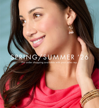 Modeling wearing gold dangle earrings.