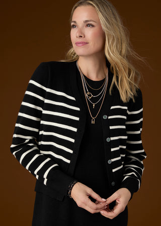 Model on brown background wearing black and white stripe sweater