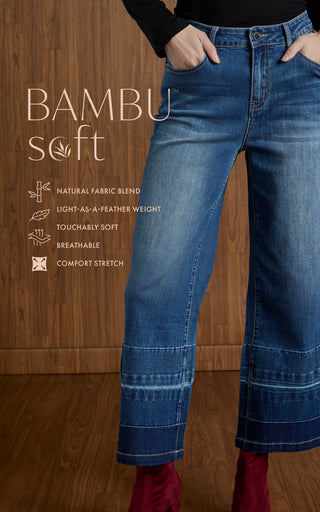 Person wearing blue jeans with 'BAMBU soft' text and features on a wooden background