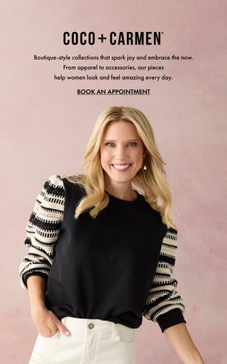 Model  wearing black long sleeve top with stripes on pink background.