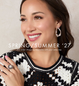 A smiling woman wearing a black and white patterned knit sweater, a silver ring on her finger, and a silver hoop earring, set against a neutral beige background with 'SPRING/SUMMER '27' text overlay.