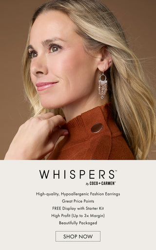 Model close-up wearing mixed metal dangle earrings on a tan background featuring 'WHISPERS' fashion earring collection.