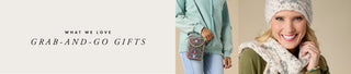 Promotional banner for grab-and-go gifts featuring a smiling woman in a knit beanie and scarf on the right, and a model holding a small patterned clutch on the left, with the text 'WHAT WE LOVE GRAB-AND-GO GIFTS' on a light beige background.