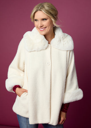 Woman wearing a cream fur coat against a purple background