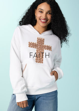 Model wearing white sweatshirt with cross on a blue background.