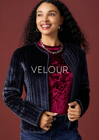 Model wearing velour shirt on a maroon background.