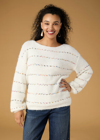Model in white sweater on tan background.
