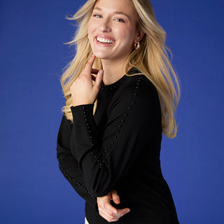 Model wearing black shirt on blue background.