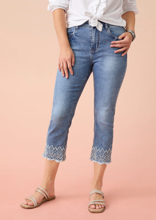 Shop denim. Model wearing blue capri jeans.