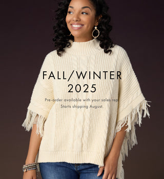 Fall/Winter '25 Preorder. Model wearing cream poncho with fringe.