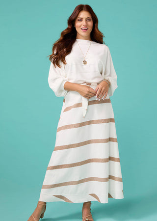 Woman wearing a white top and striped skirt against a teal background