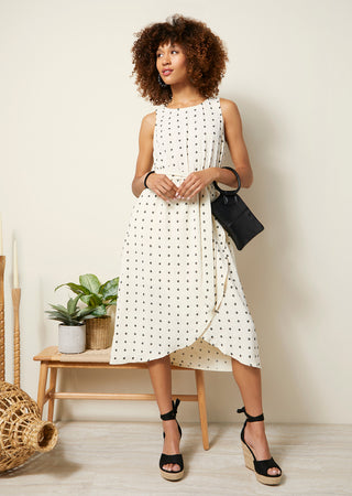 Model wearing a cream summer dress with polka dots.