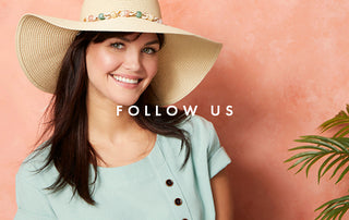 Model wearing a light blue button summer top and ranch hat.