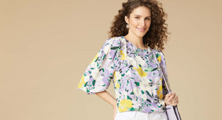 Model wearing a purple and yellow floral blouse.