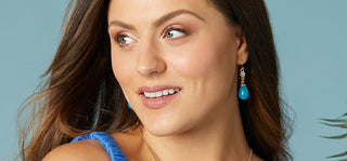 Model wearing blue teardrop dangle earrings.