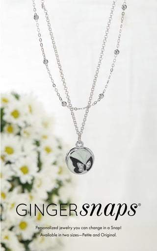 Necklace with a round pendant featuring a butterfly design, on a white background with 'Gingersnaps' branding.