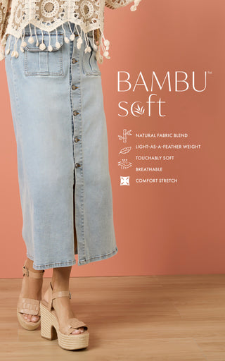 Person wearing a long light blue denim skirt with text about 'BAMBU soft' fabric on a peach background.